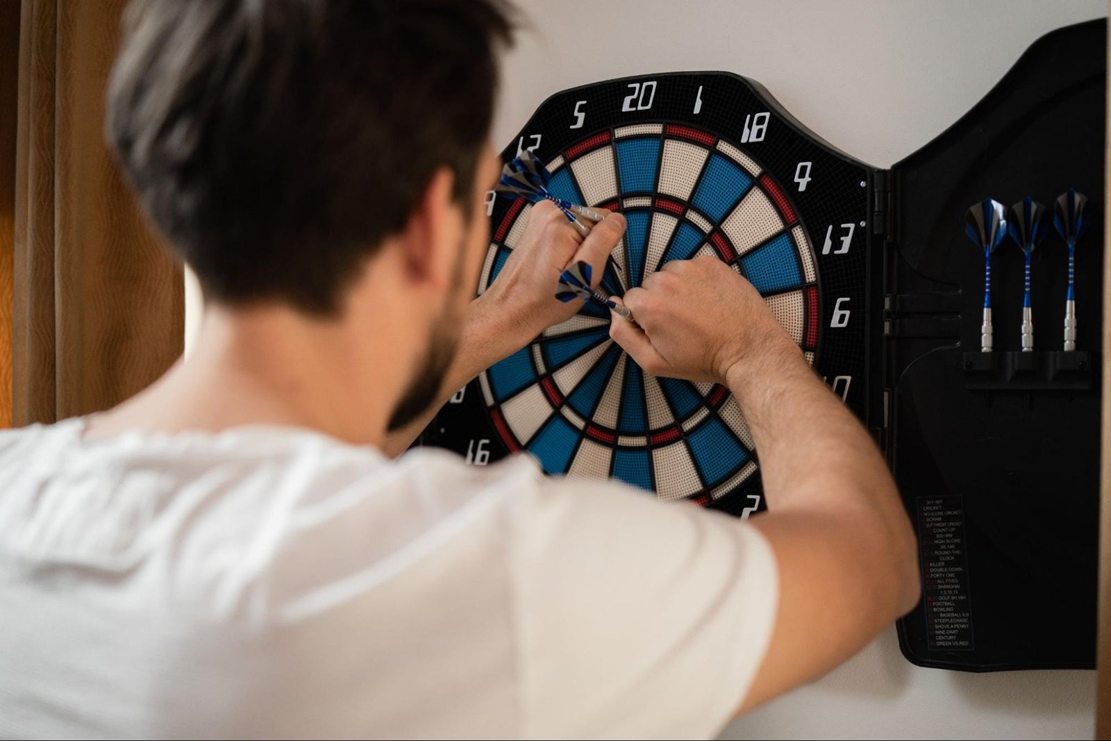 the surrounding space, wall, flooring, and lighting should be considered when hanging a dart board