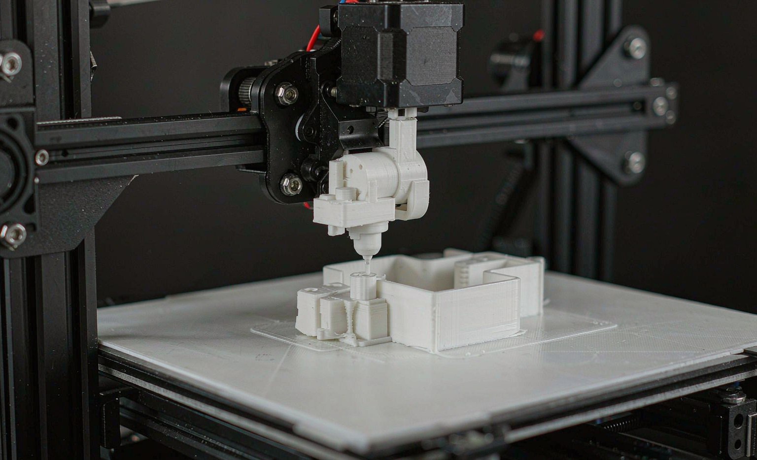 Desktop FDM 3D printer extruding a plastic part