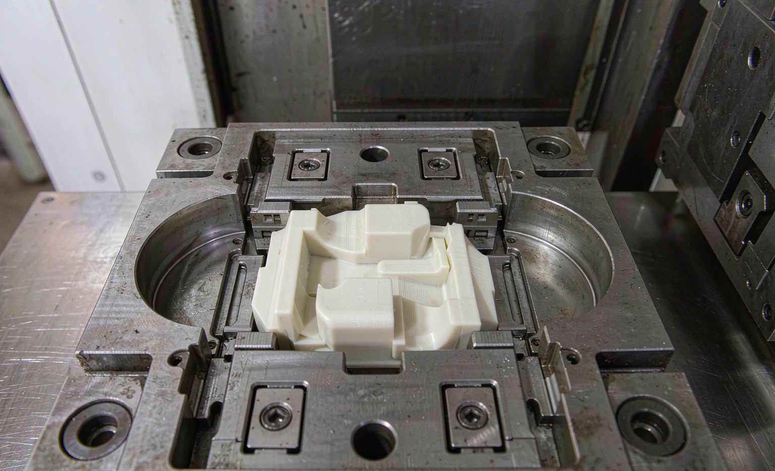 Steel injection mold cavity with an ejected molded plastic part