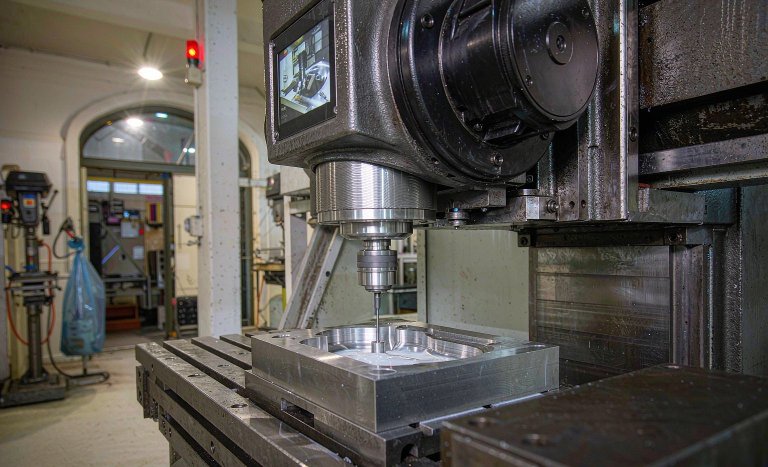 CNC milling machine cutting a steel injection mold cavity