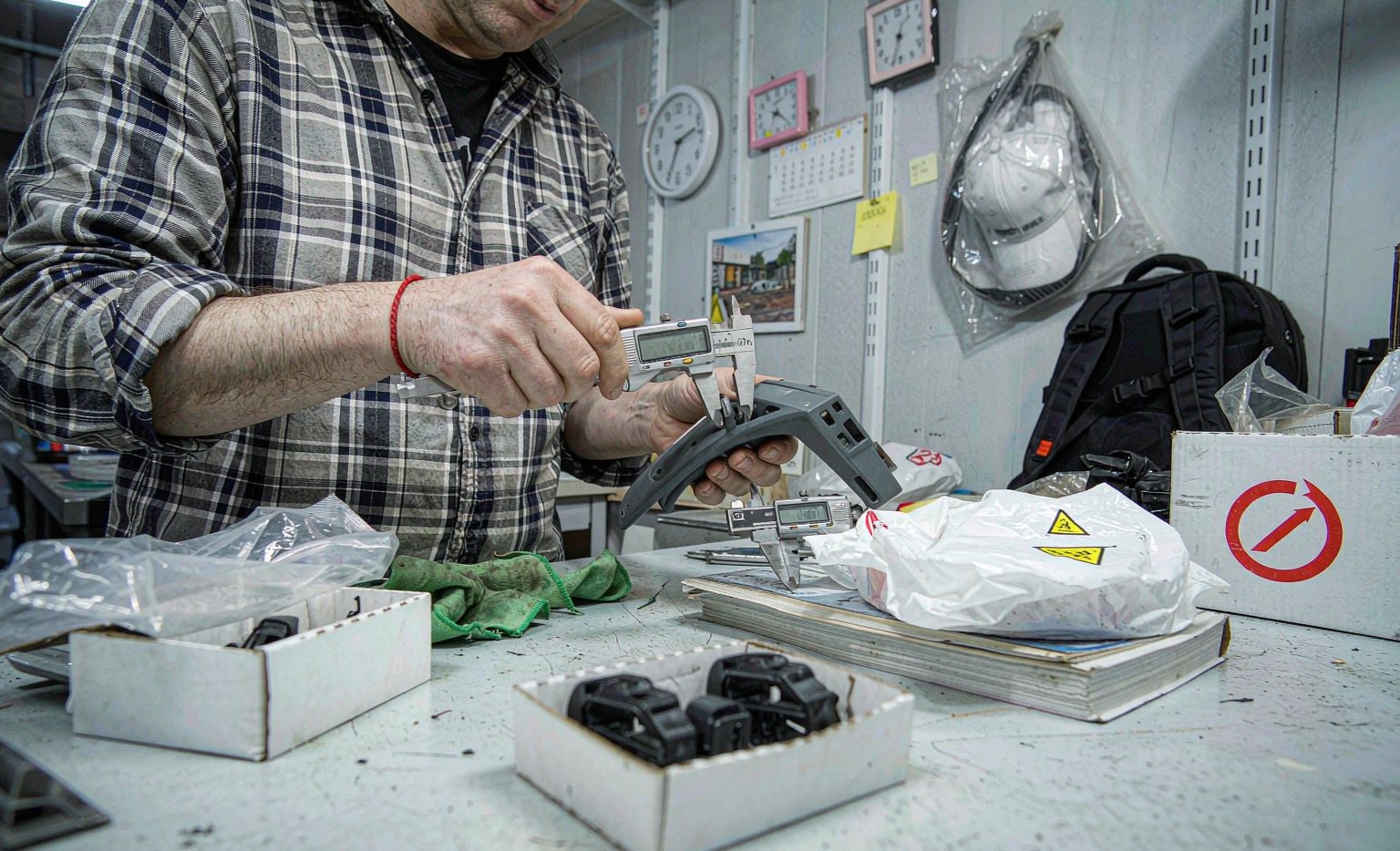 Quality inspector measuring a molded plastic part with calipers