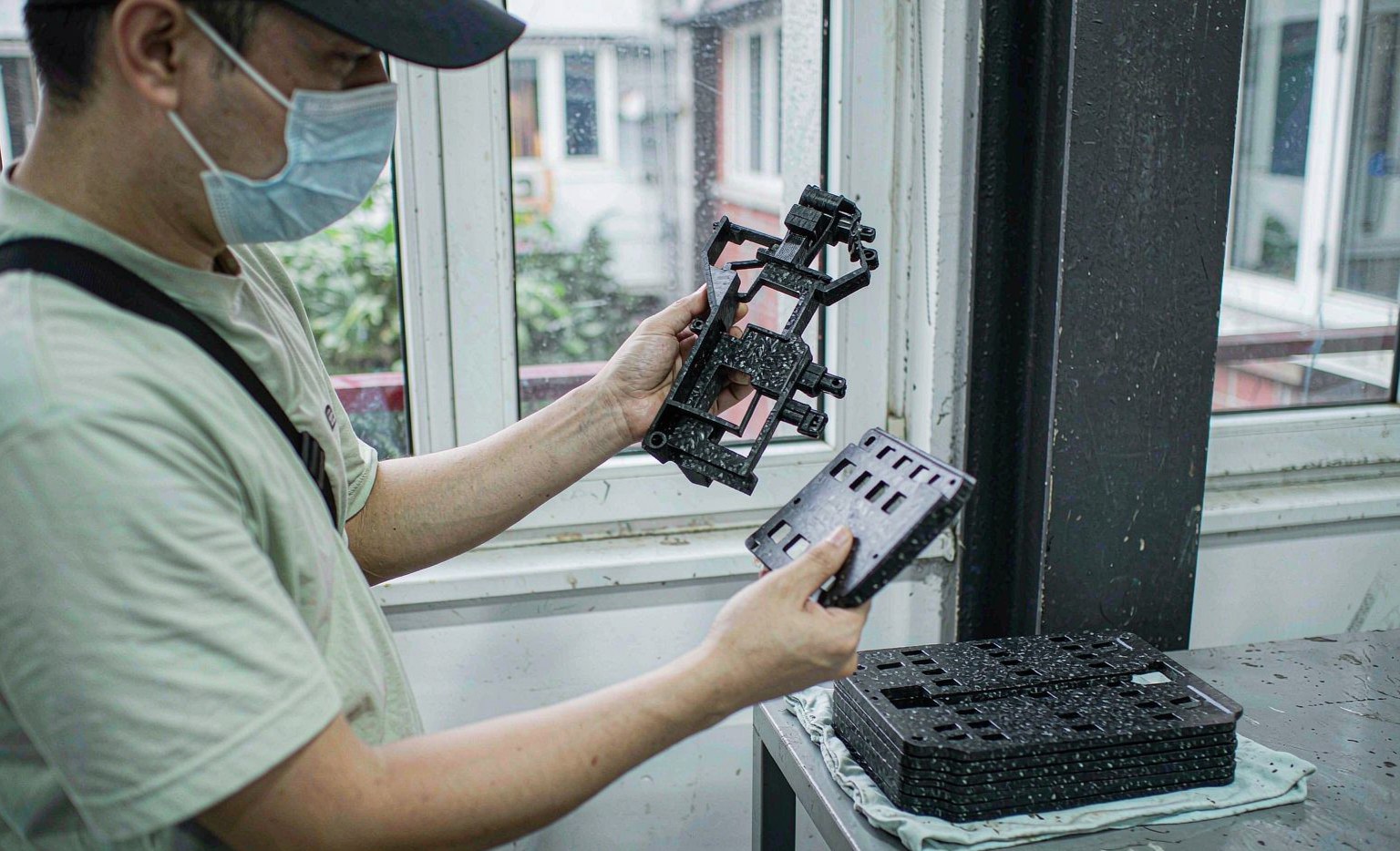 Engineer comparing a 3D printed prototype with an injection molded part