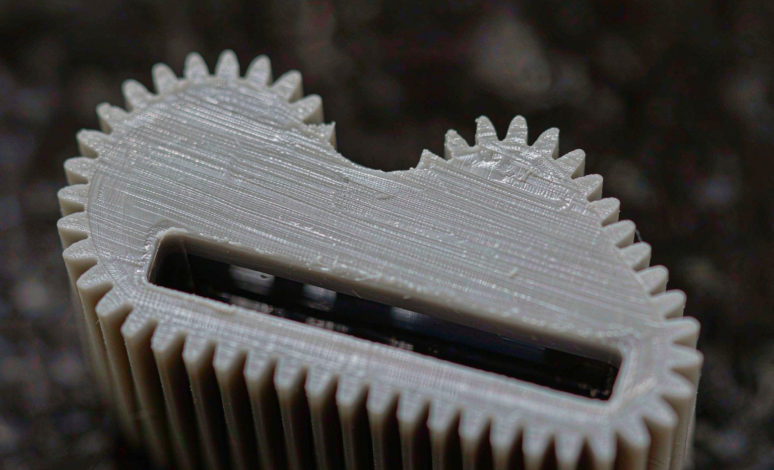 Macro of a precisely molded plastic gear showing a tight tolerance surface