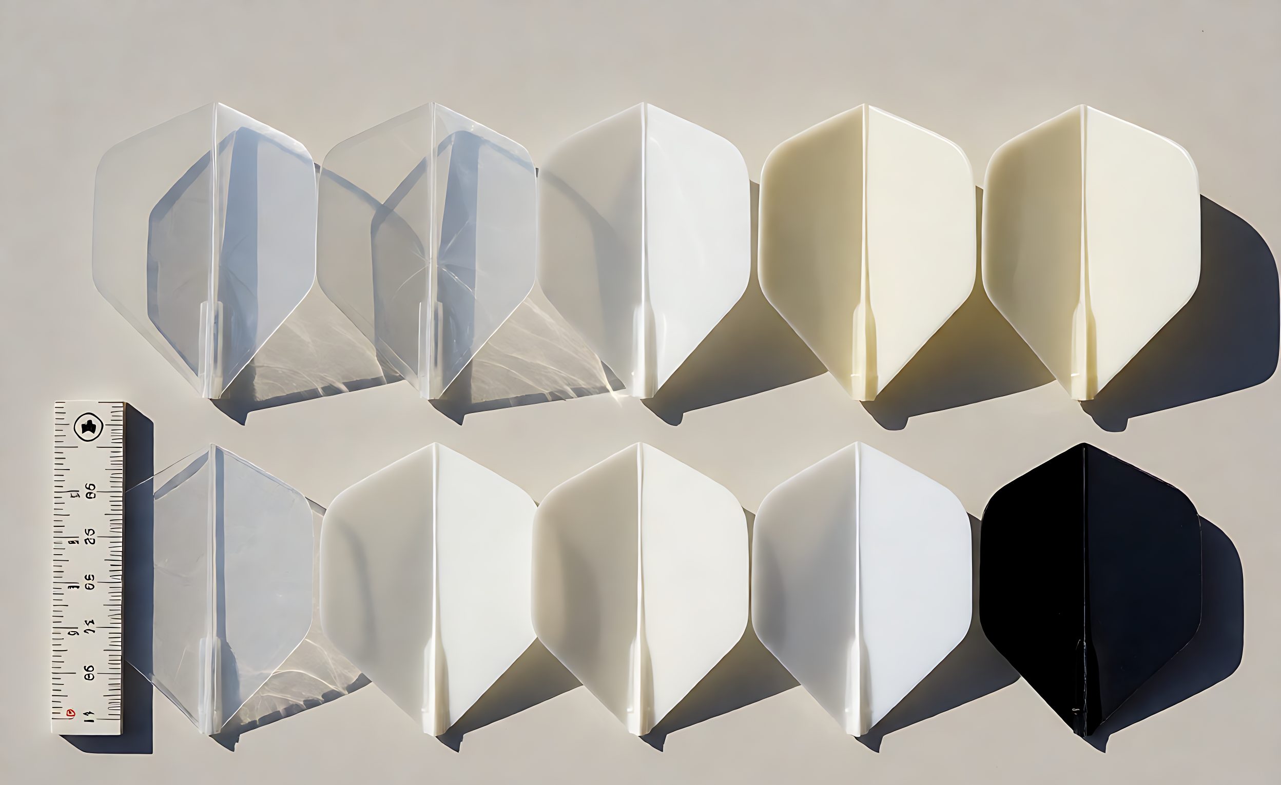 Dart flights in polyester film and moulded plastic laid out with a thickness gauge