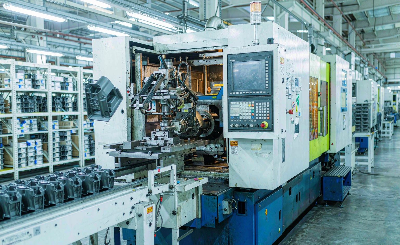 Industrial injection molding machine producing plastic parts in a factory