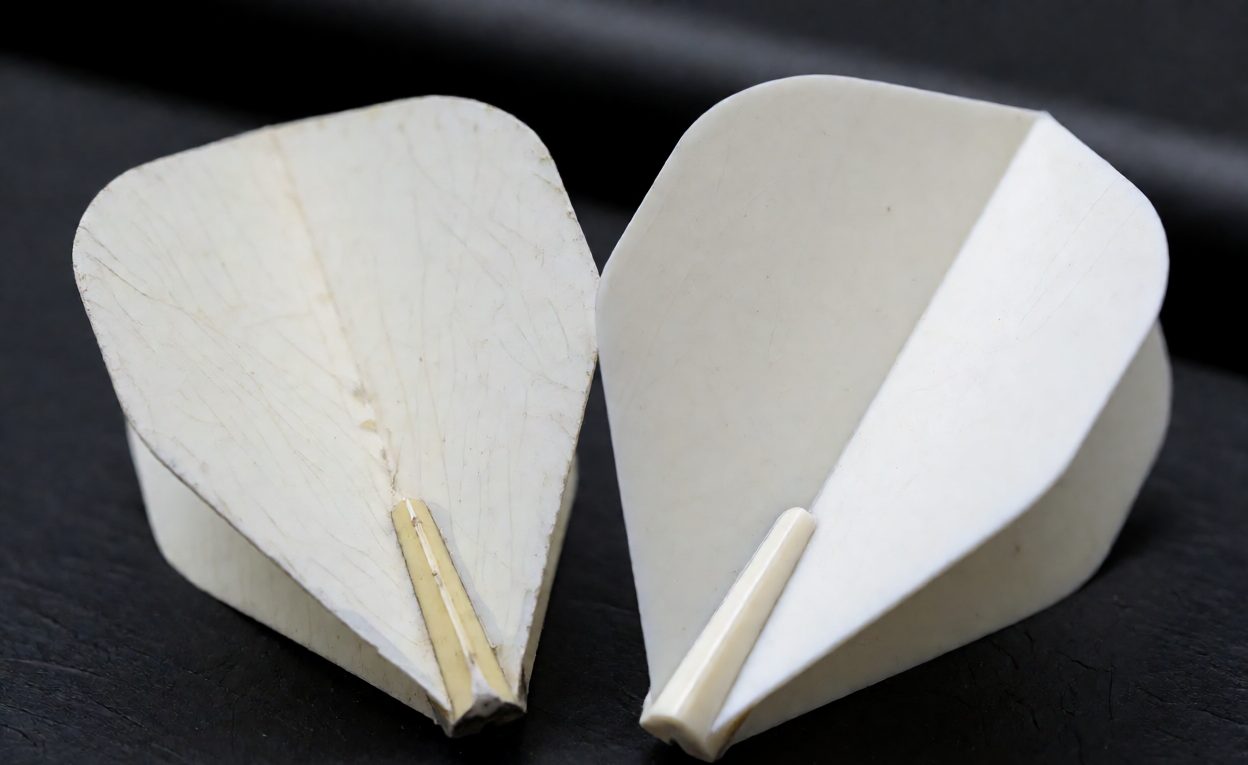 Wear comparison after repeated play Used folded film flight with a worn crease beside an intact moulded flight